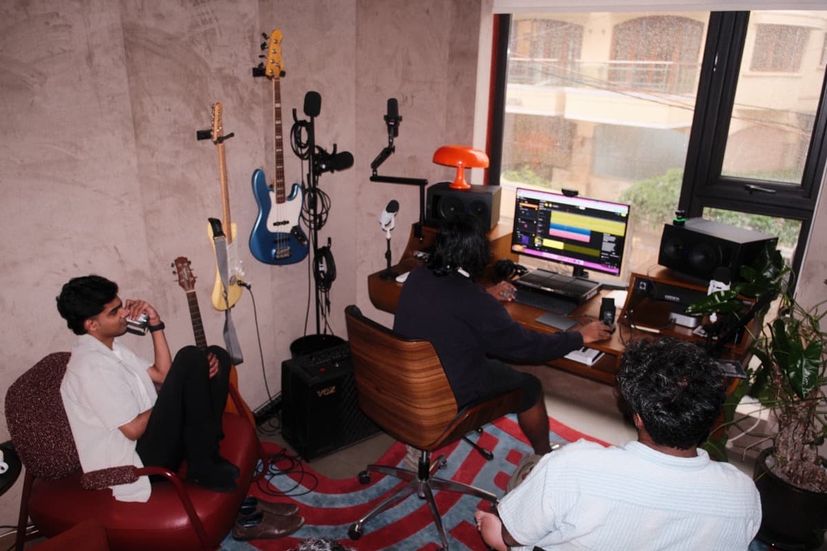 Sidharth Bendi making a track on riffle in a studio while the crew watches